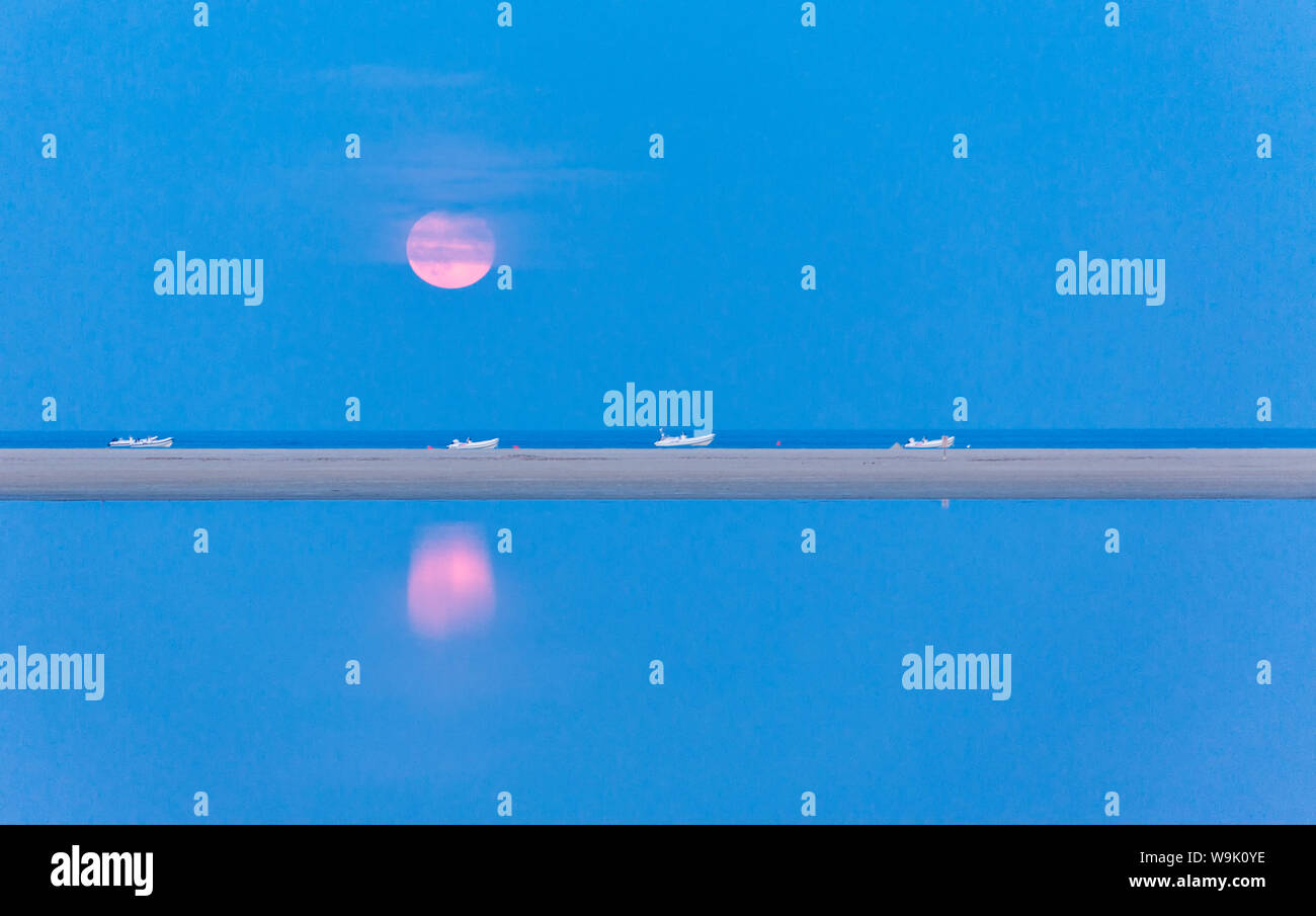 La rosa la luna piena è riflessa in blu e di acqua di stagno di Notteri, Villasimius, provincia di Cagliari, Sardegna, Italia, Mediterraneo, Europa Foto Stock