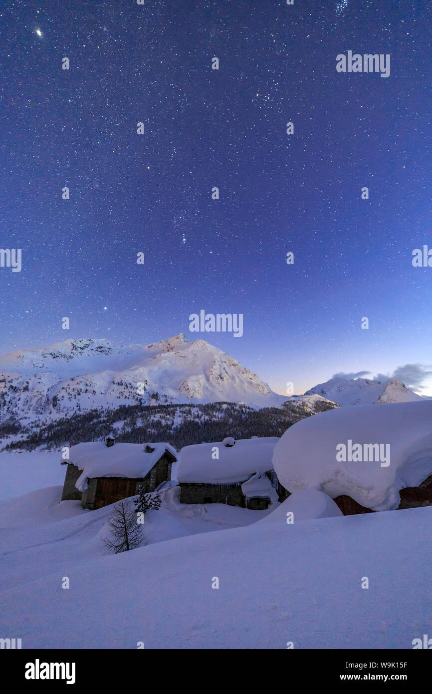 Le capanne di Spluga coperto di neve spessa durante una chiara notte stellata, Grigioni, alpi svizzere, Svizzera, Europa Foto Stock