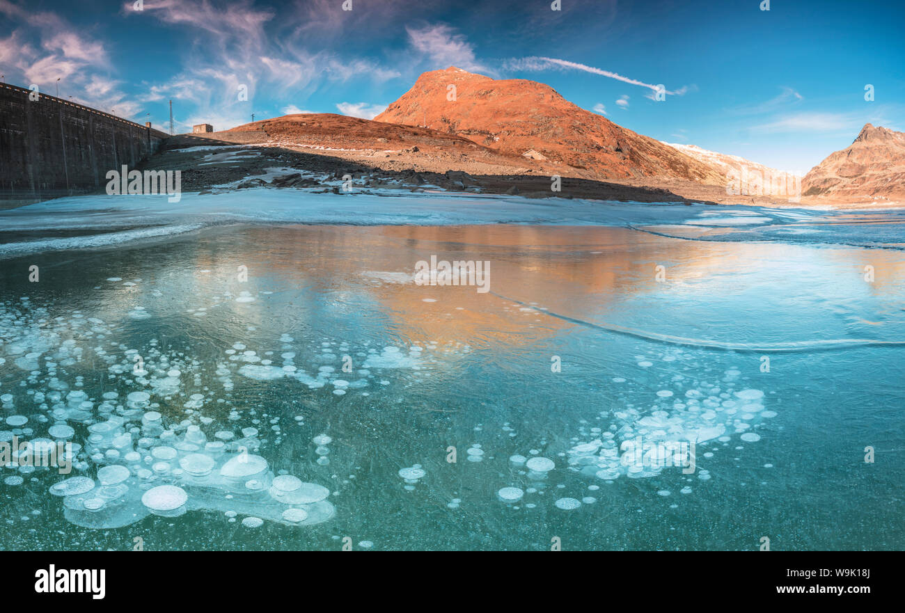 Panoramica del lago ghiacciato di Montespluga all'alba, Val Chiavenna, provincia di Sondrio e della Valtellina, Lombardia, Italia, Europa Foto Stock