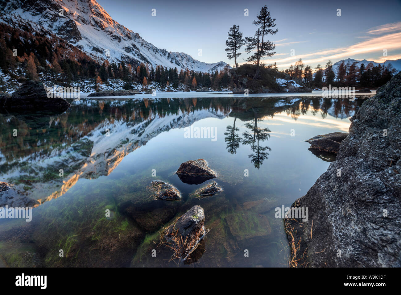 Autunno riflessi al Lago Saoseo ancora parzialmente congelato, Valle di Poschiavo, Cantone dei Grigioni, Svizzera, Europa Foto Stock