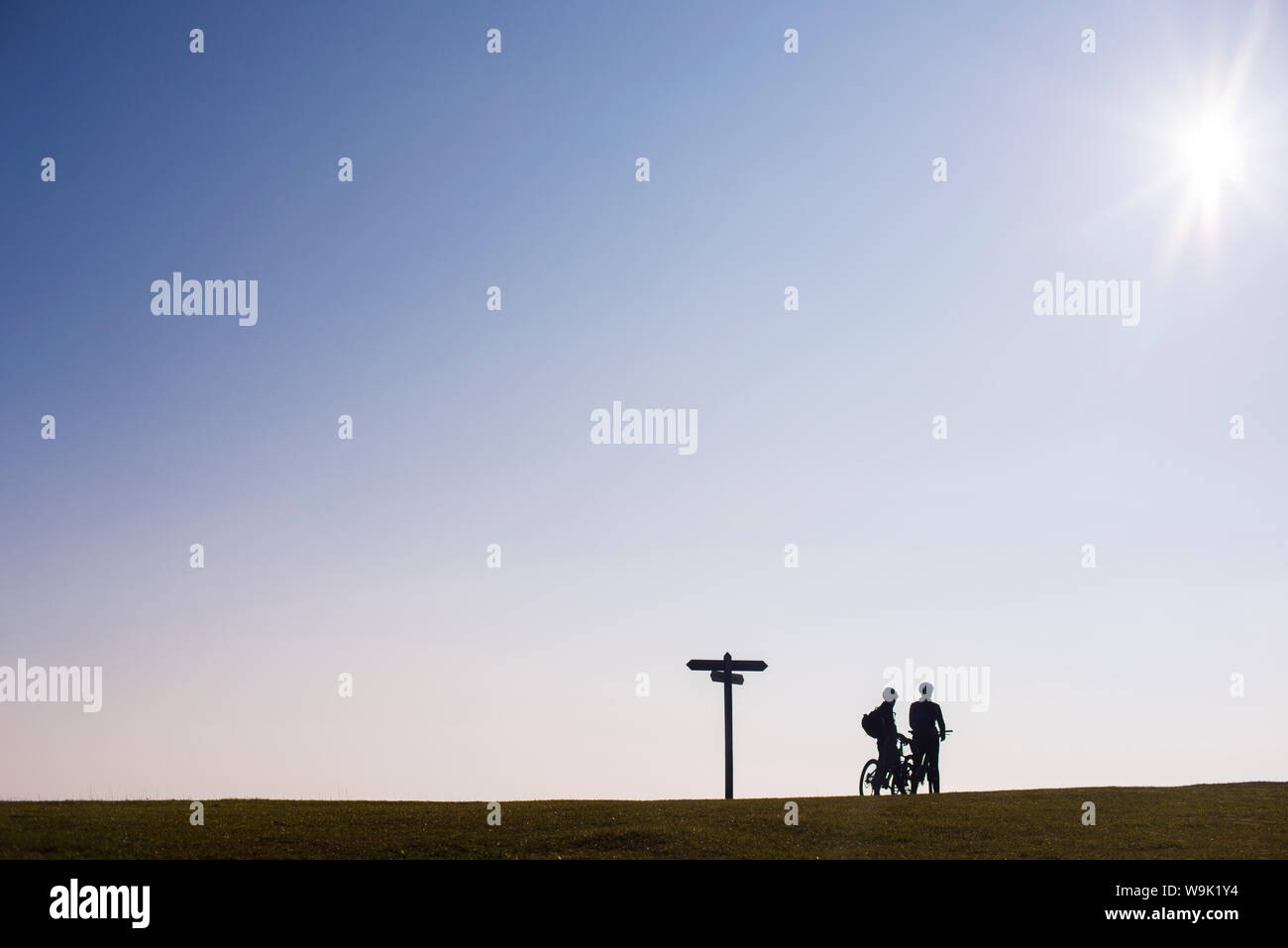 I ciclisti si prendono una pausa sul ciglio di una collina al tramonto nel Dorset, England, Regno Unito, Europa Foto Stock