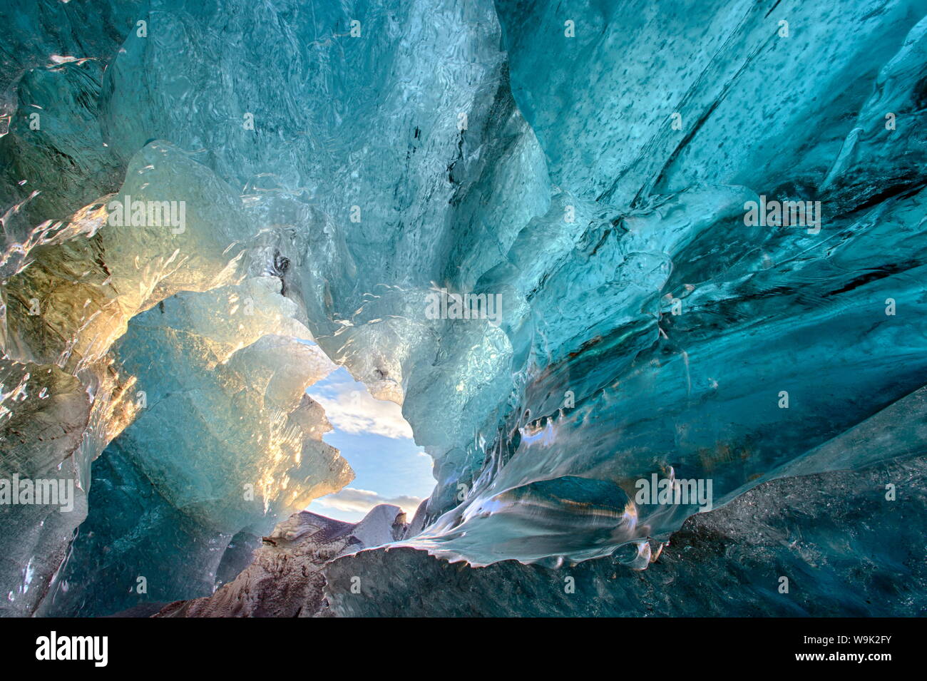 Vista dentro una caverna di ghiaccio sotto il sud ghiacciaio Vatnajokull, acquisite a sunrise durante la stagione invernale quando le grotte di ghiaccio sono accessibili, Jokulsarlon, Islanda Foto Stock