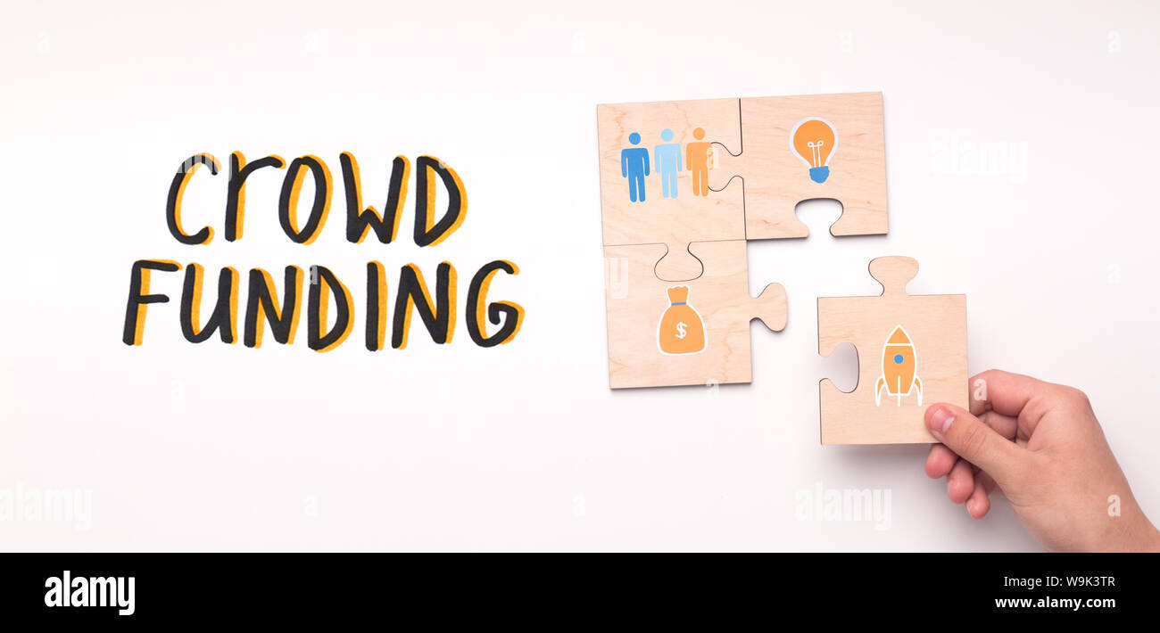 Concetto di Crowdfunding su puzzle in legno di pezzi con icone Foto Stock