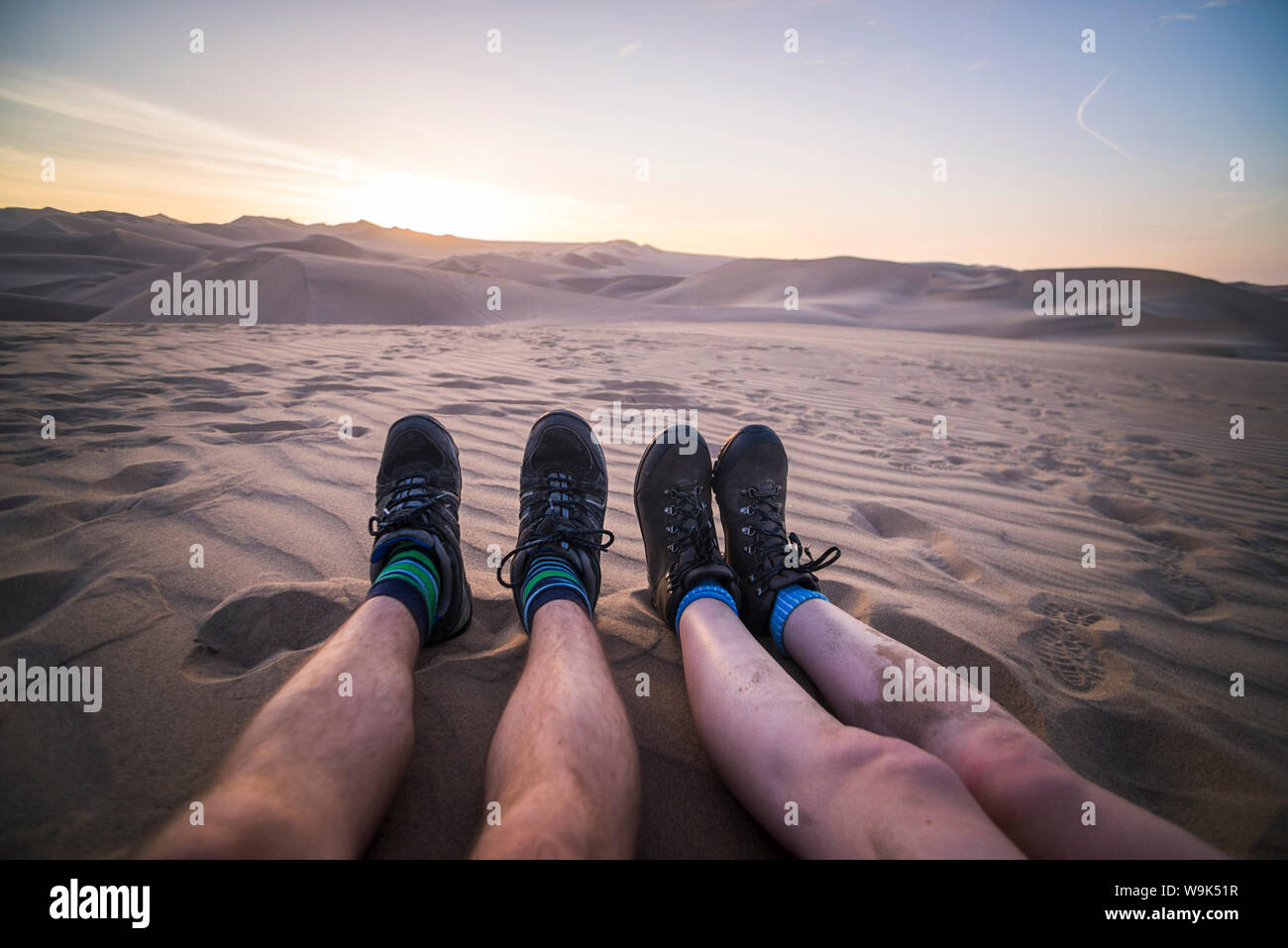 Giovane e guardare il tramonto sopra le dune di sabbia del deserto di Huacachina, Regione di Ica, Perù, Sud America Foto Stock