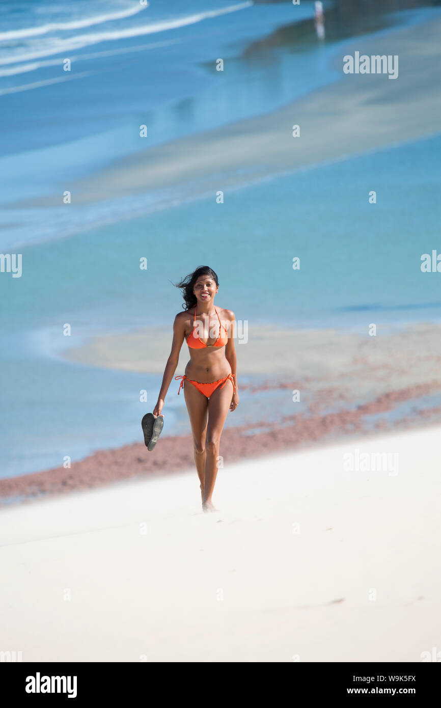 Una giovane donna a piedi lungo la spiaggia di Jericoacoara, Ceara, Brasile, Sud America Foto Stock