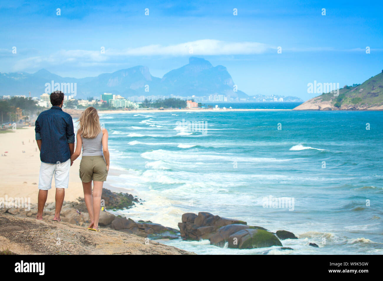 Una giovane coppia che affaccia sulla Spiaggia del Pontal, Barra da Tijuca e la Pedra da Gavea, Stato di Rio de Janeiro, Brasile, Sud America Foto Stock