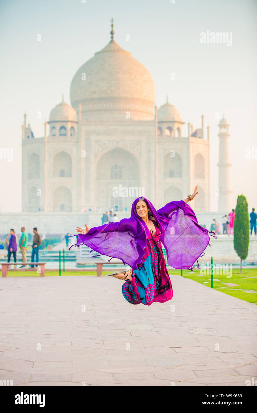 Laura Grier saltando al Taj Mahal, Sito Patrimonio Mondiale dell'UNESCO, Agra, Uttar Pradesh, India, Asia Foto Stock