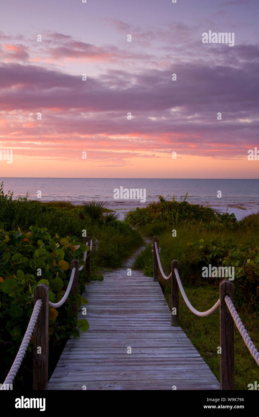 Una passerella oltre le dune di sabbia e vegetazione tropicale che conduce alla spiaggia di sunrise, Sanibel Island, Florida, Stati Uniti d'America, America del Nord Foto Stock