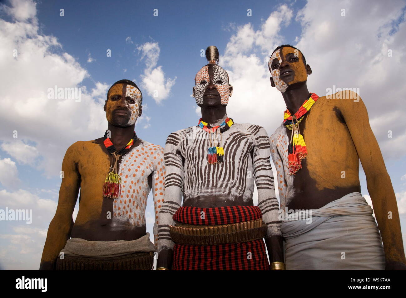 Ritratto di tre Karo tribesmen con visi e corpi verniciati con chalk imitando il piumaggio maculato della faraona, Omo, Etiopia Foto Stock