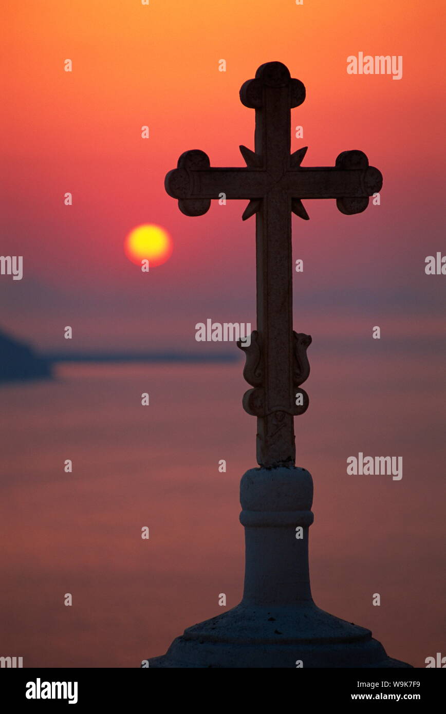 Croce sulla cupola della chiesa con il sole che tramonta dietro, Fira, Santorini, Cicladi, isole greche, Grecia, Europa Foto Stock