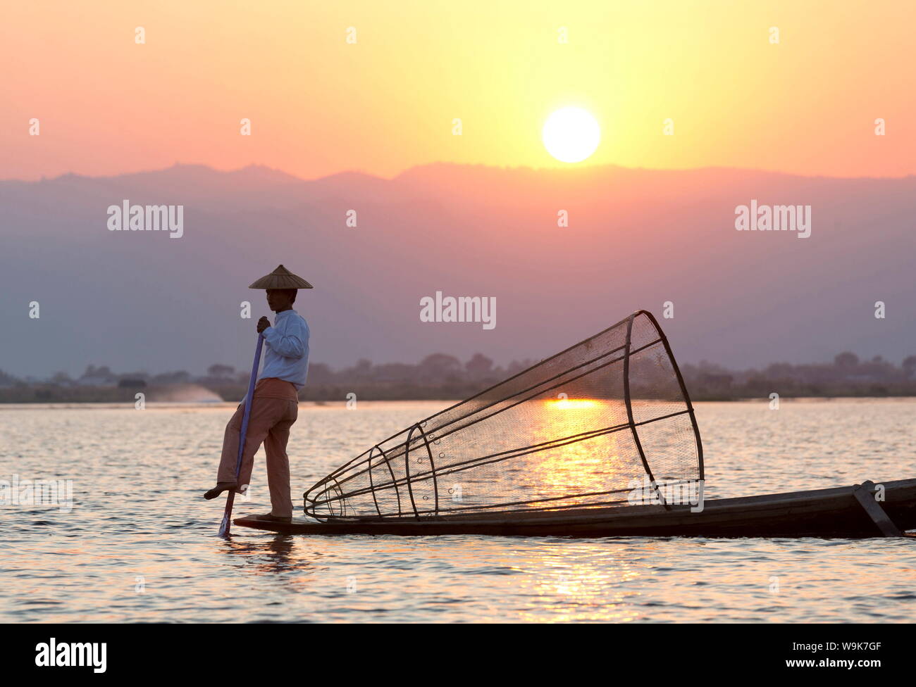 Gamba Intha canottaggio pescatori al tramonto sul Lago Inle, Lago Inle, Stato Shan, Myanmar Foto Stock