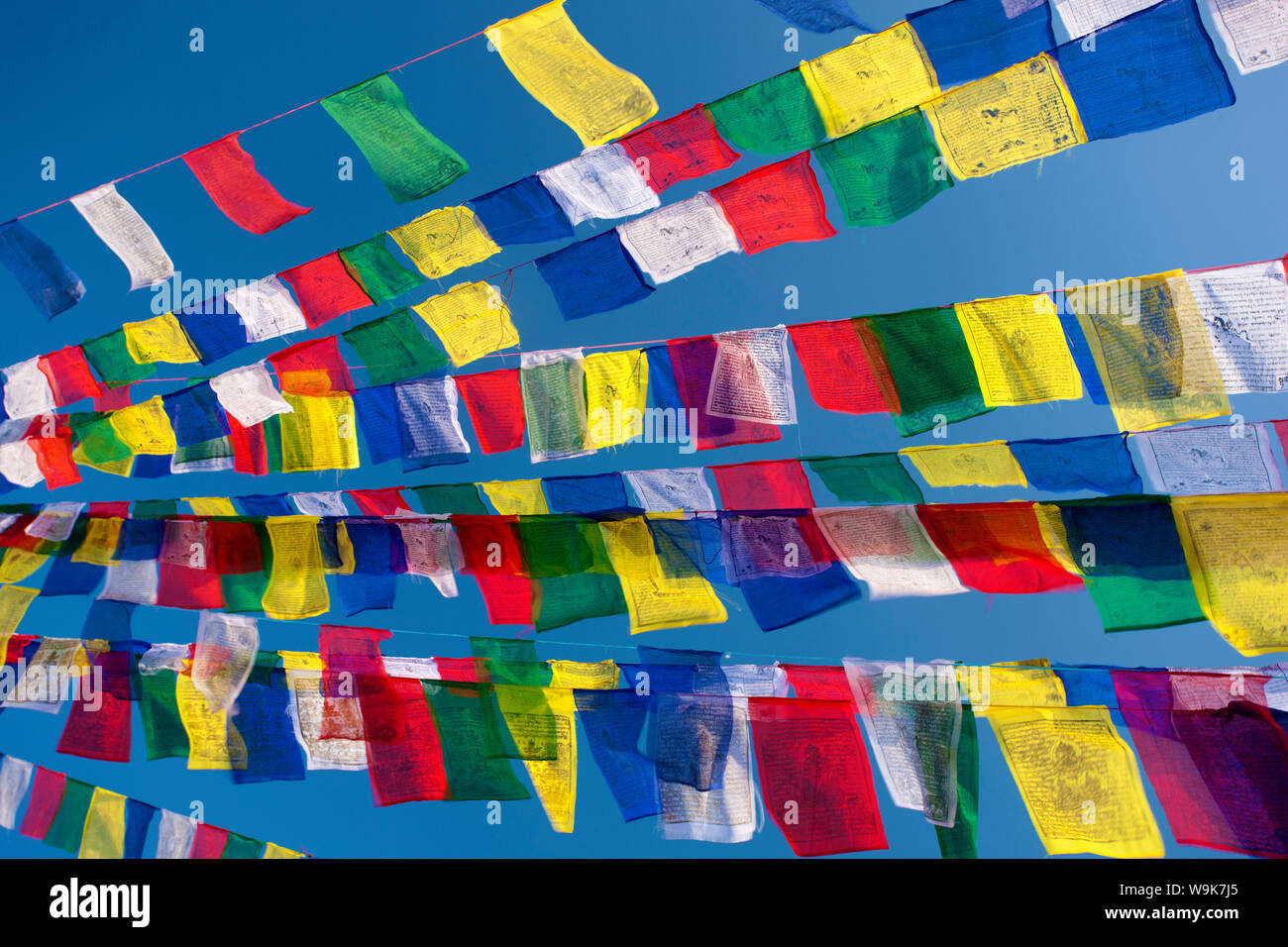 Preghiera colorati bandiere contro il cielo blu e chiaro a Bodhnath Stupa (Boudhanth) (Boudha), uno del santissimo siti buddista a Kathmandu, Kathmandu, Nepal Foto Stock
