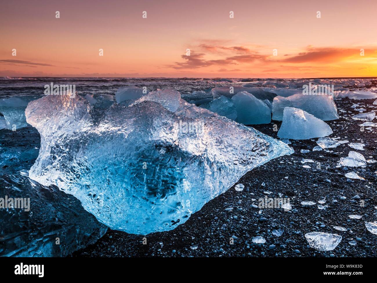 Rotto il ghiaccio da lavato fino iceberg sulla Jokulsarlon spiaggia nera al tramonto, Jokulsarlon, sud-est di Islanda, Islanda, regioni polari Foto Stock