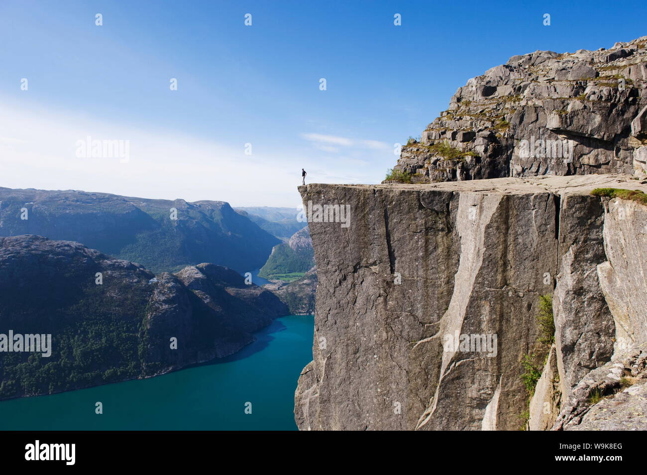 Uomo in piedi sul Prekestolen (il pulpito Rock) sopra il fiordo, Lysefjord, Norvegia, Scandinavia, Europa Foto Stock