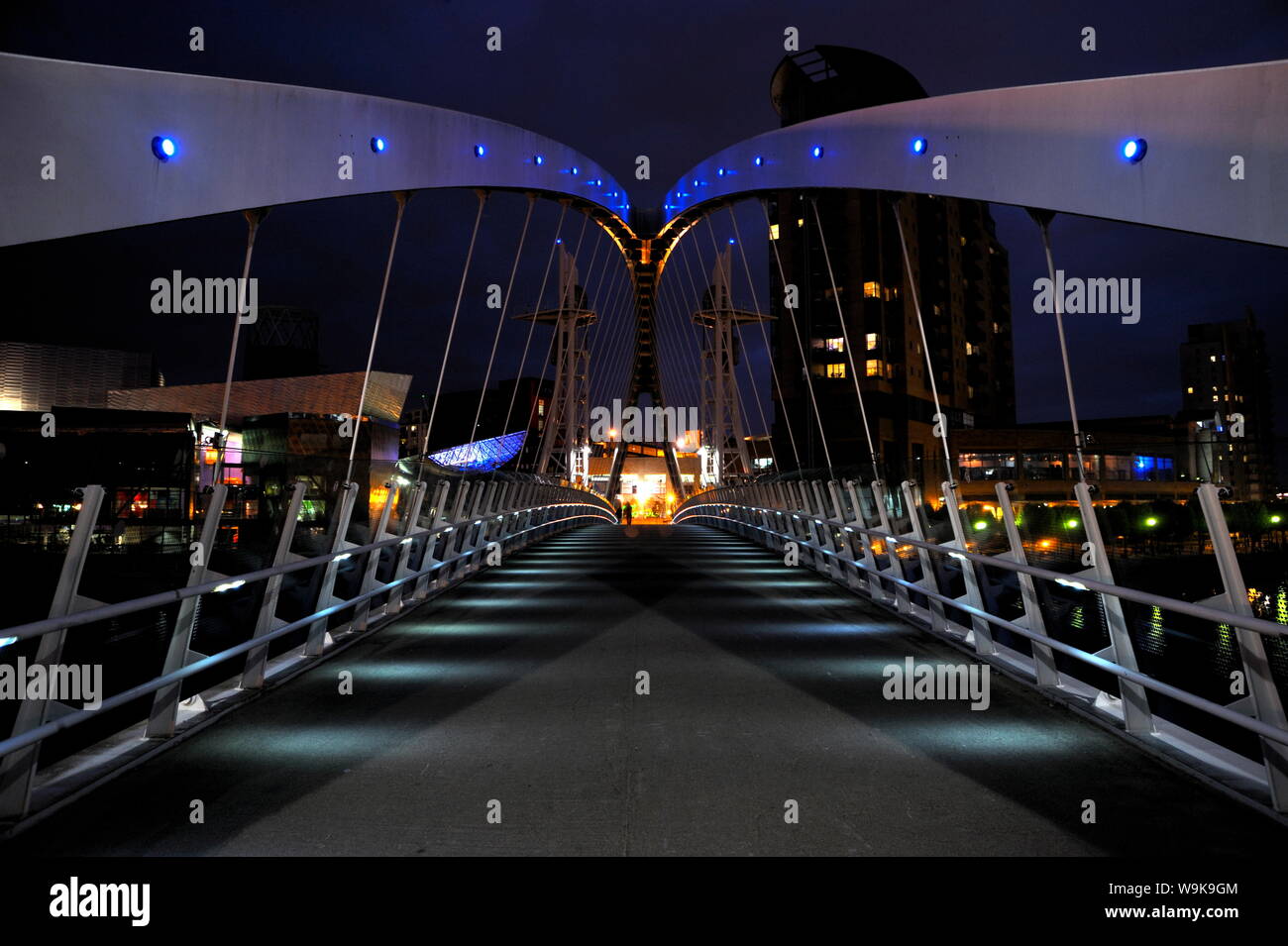 Vista notturna di The Lowry ponte sopra il Manchester Ship Canal, Salford Quays, Greater Manchester, Inghilterra, Regno Unito, Europa Foto Stock
