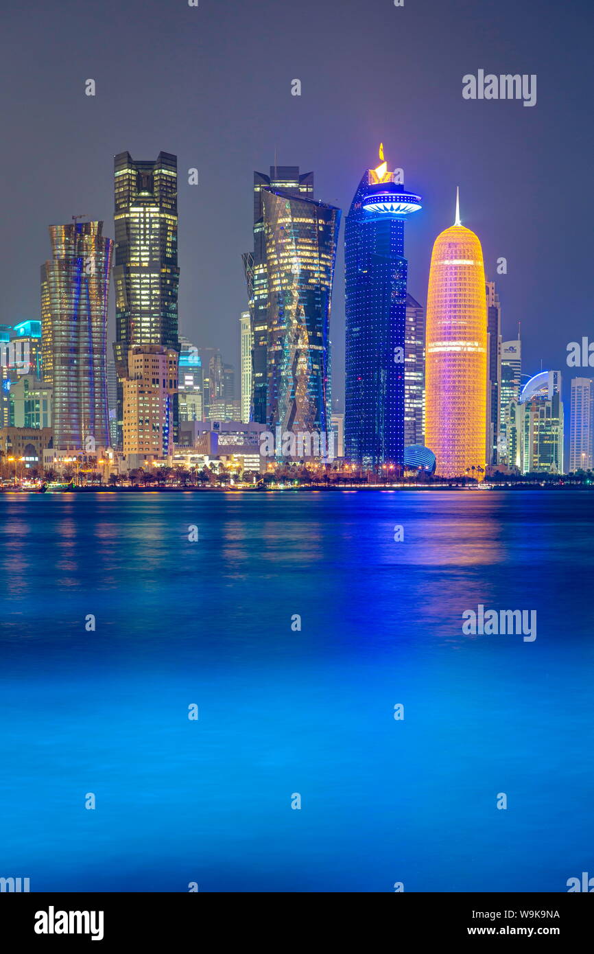 Nuovo skyline del West Bay quartiere finanziario centrale di Doha, illuminate al tramonto, Doha, Qatar, Medio Oriente Foto Stock