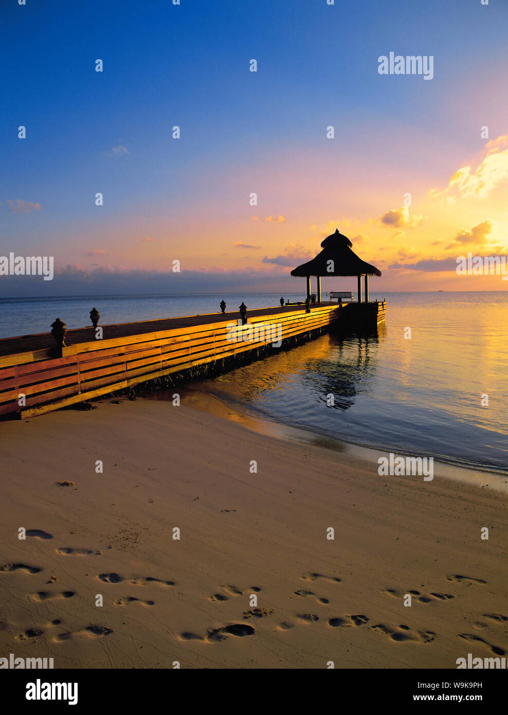 Pontile sulla spiaggia al tramonto, Maldive, Oceano Indiano, Asia Foto Stock