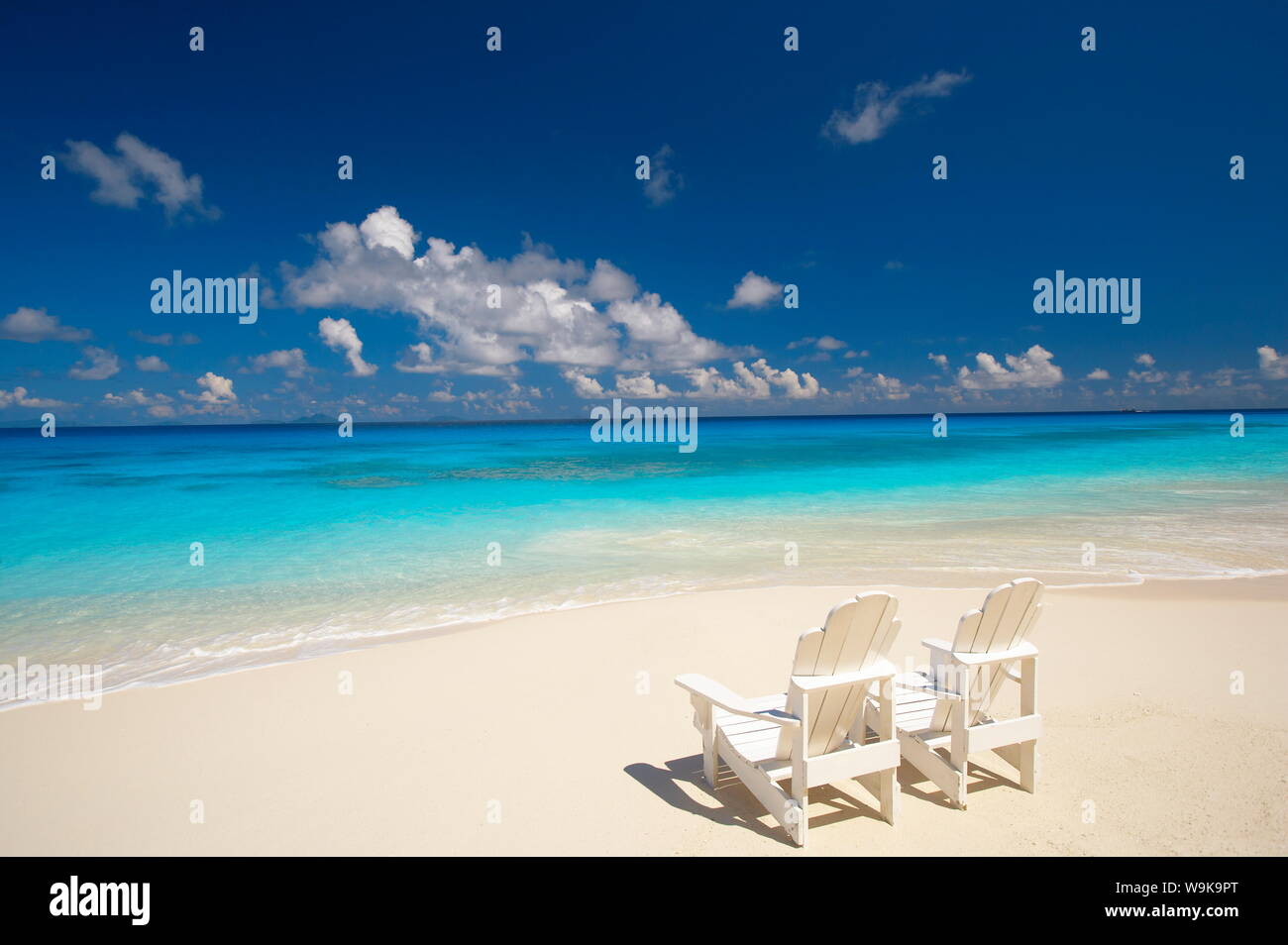 Due sedie a sdraio sulla spiaggia tropicale di fronte al mare, Maldive, Oceano Indiano, Asia Foto Stock