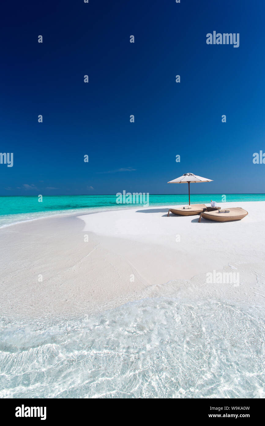 Due sedie a sdraio con ombrellone su una spiaggia tropicale, Maldive, Oceano Indiano, Asia Foto Stock