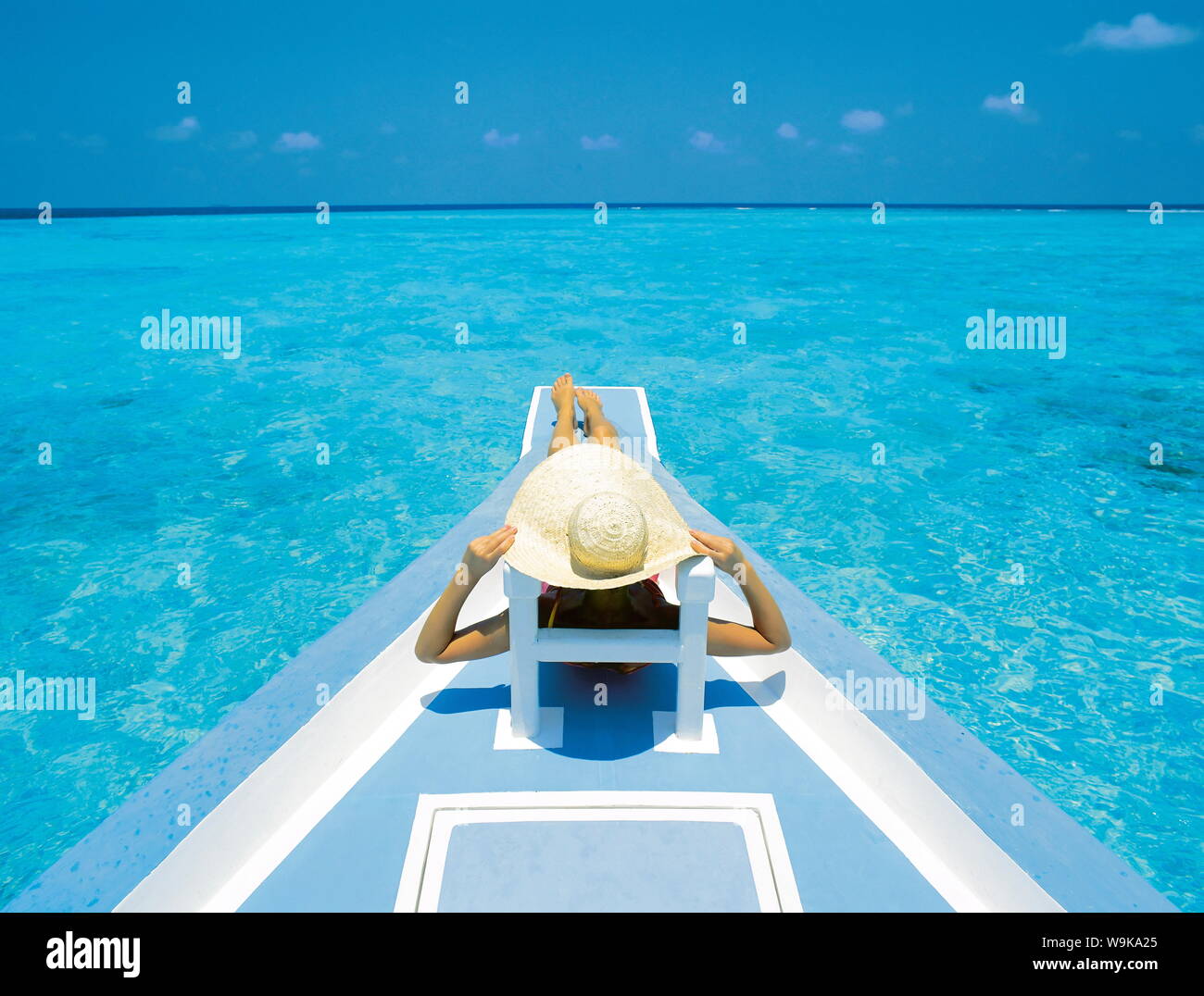 Donna rilassante sul ponte della barca, Maldive, Oceano Indiano, Asia Foto Stock