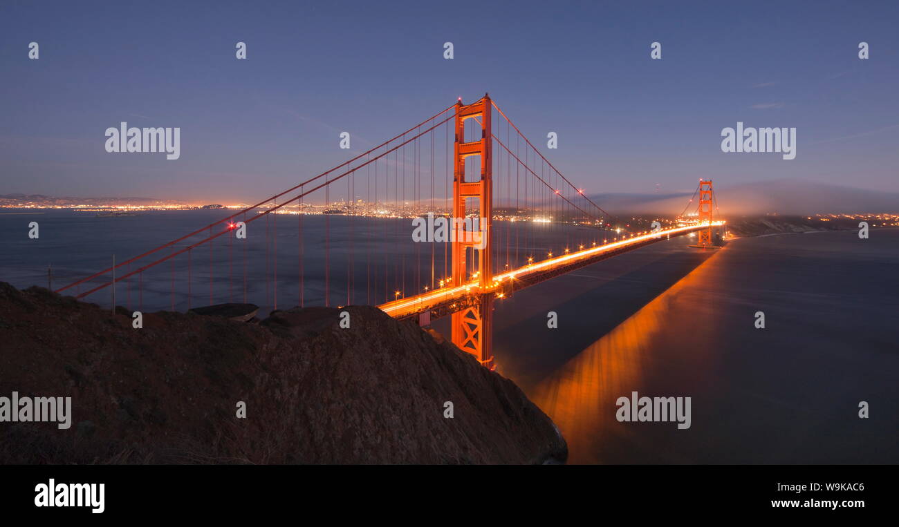Golden Gate Bridge incandescente al tramonto con lo skyline di San Francisco dietro, visto dal Marin Headlands, San Francisco, California, Stati Uniti d'America Foto Stock