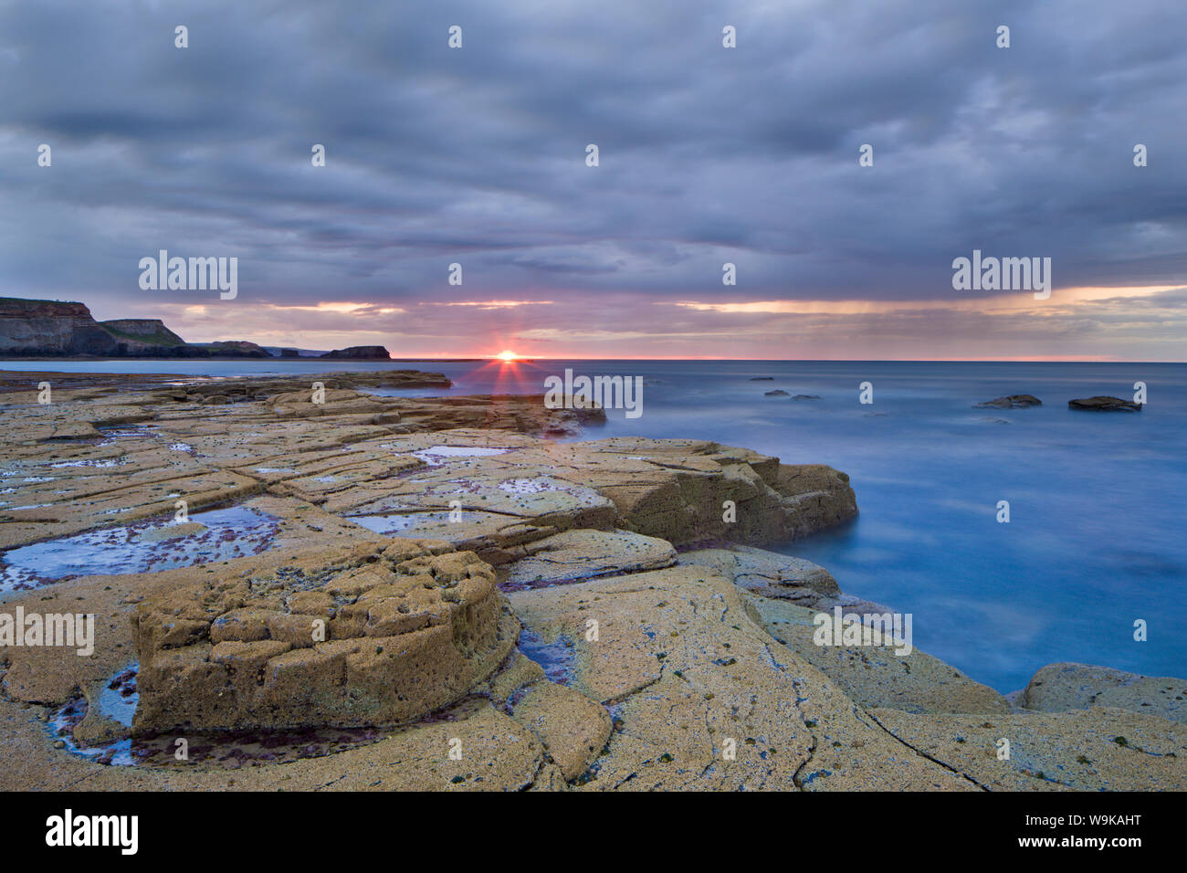 Tramonto su una serata showery a Saltwick Bay, North Yorkshire, Yorkshire, Inghilterra, Regno Unito, Europa Foto Stock