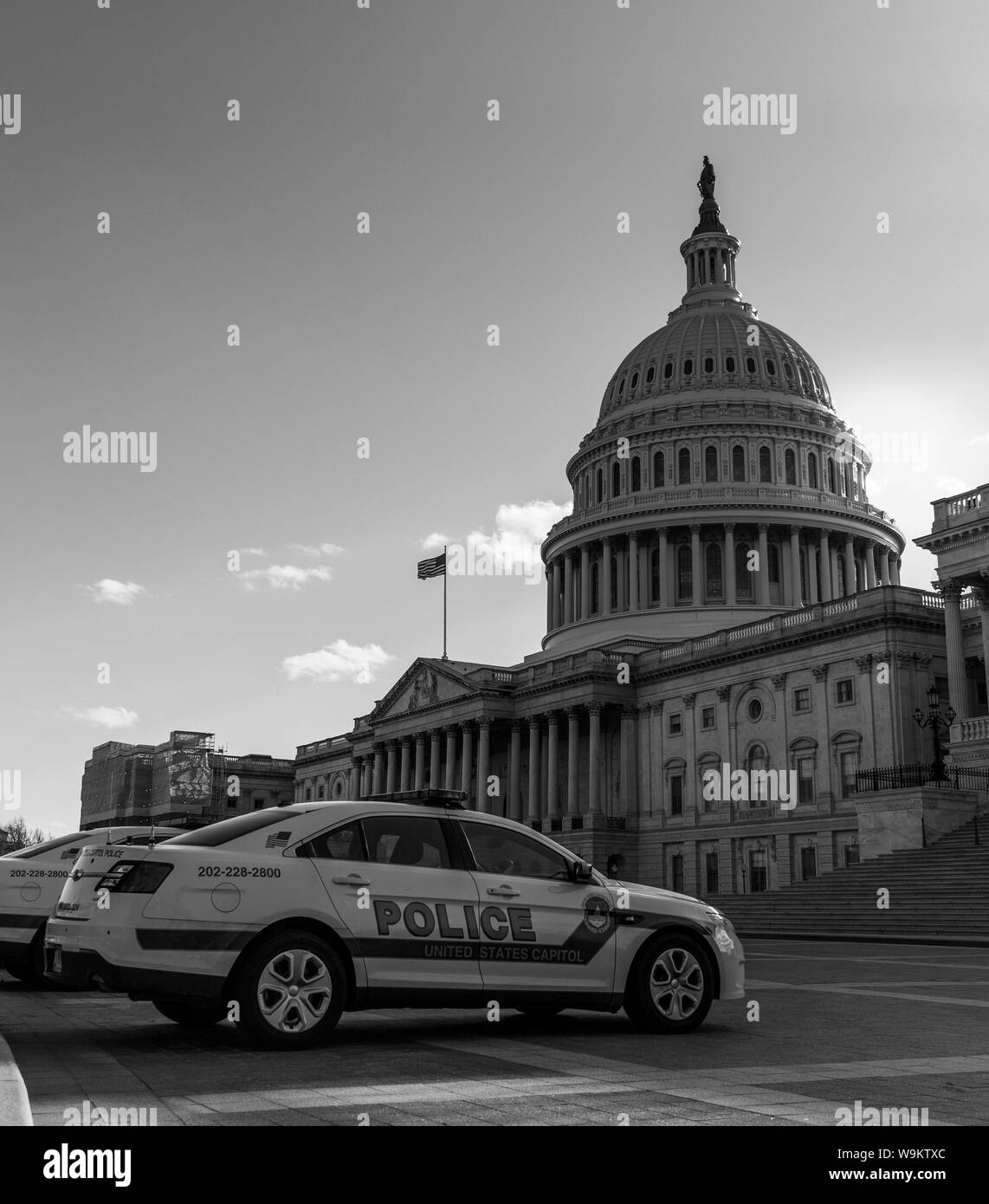 Una foto in bianco e nero di un'auto della polizia nella parte anteriore del Campidoglio degli Stati Uniti. Foto Stock