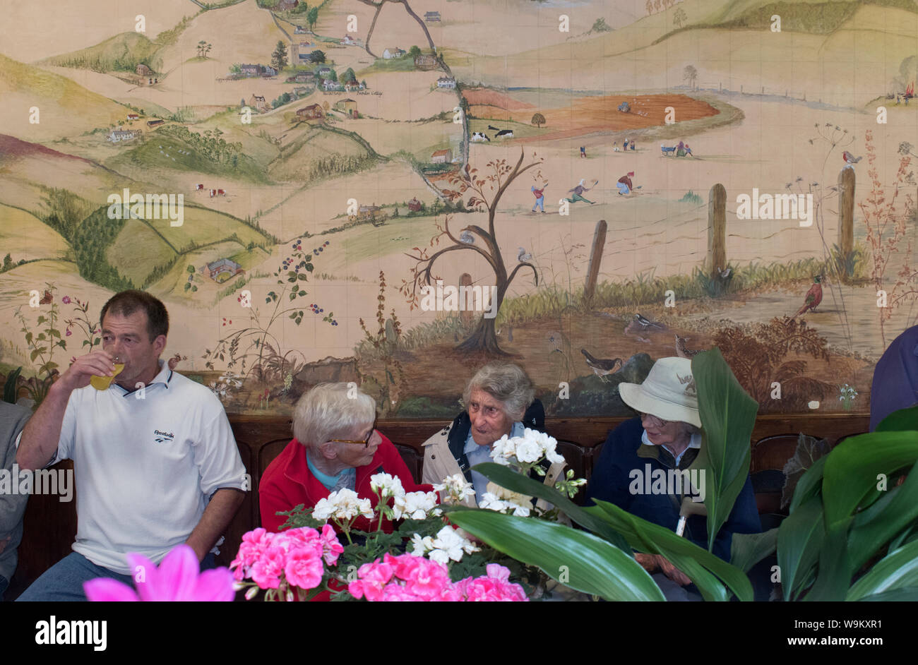 Mostra dei fiori del villaggio degli anni '2010 Regno Unito. Donne anziane ad un evento della comunità Brompton Ralph, Somerset 2019 . Dipingere sul muro del municipio del villaggio è della loro comunità nella West Country England HOMER SYKES Foto Stock