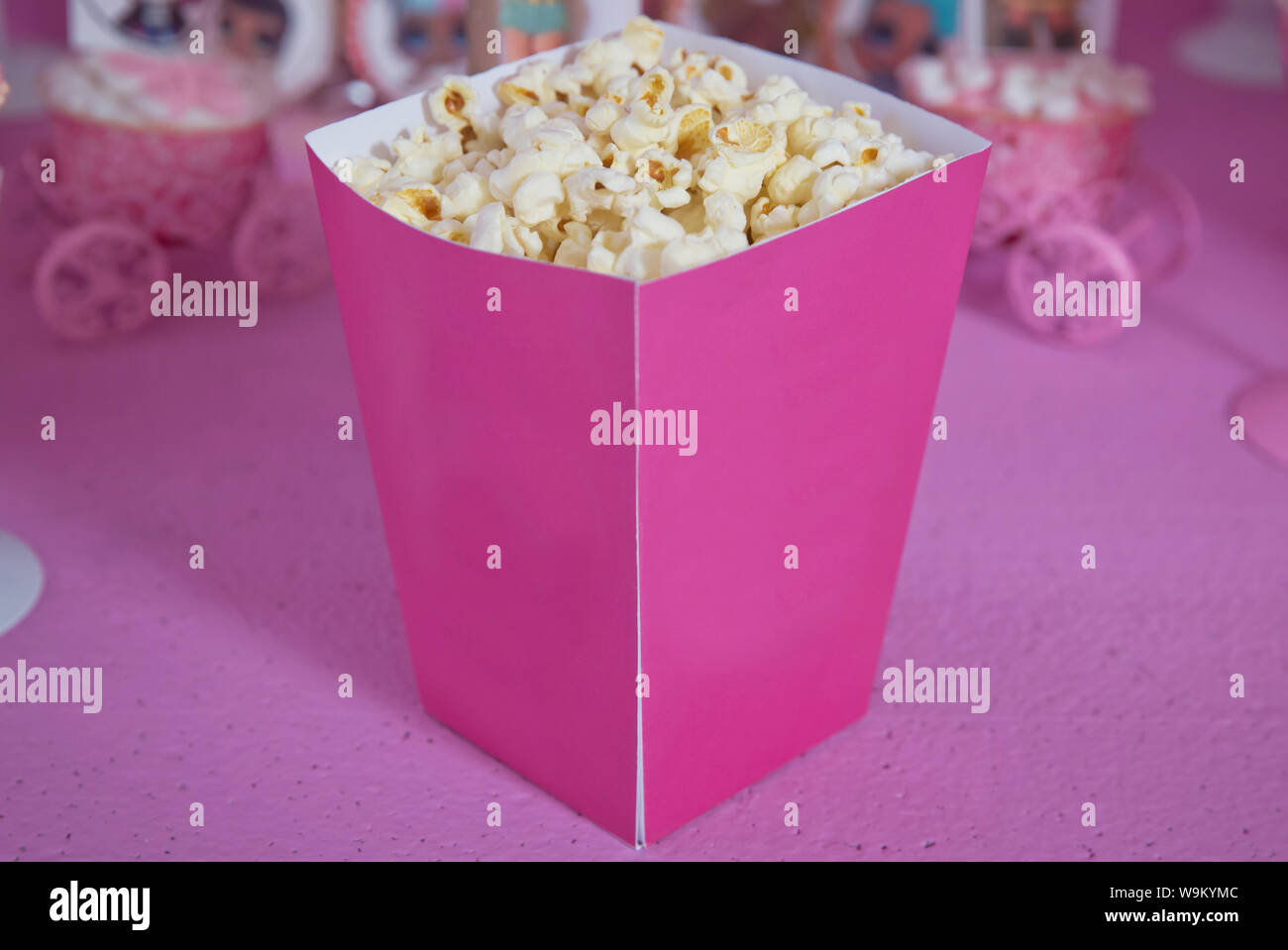 Un ampio box classico del teatro di popcorn isolati su rosa . Il Popcorn rovesciato da una scatola con striping . Tre vintage-style di scatole di popcorn in un tema di carnevale Foto Stock