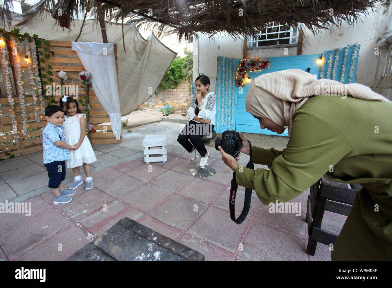 La città di Gaza, Striscia di Gaza, Territori palestinesi. 14 Ago, 2019. Un fotografo palestinese prende le immagini dei bambini durante un servizio fotografico al suo studio, il quarto giorno di Eid al-Adha o la festa del sacrificio, nella Striscia di Gaza City il 14 agosto 2019 Credit: Mahmoud Ajjour APA/images/ZUMA filo/Alamy Live News Foto Stock