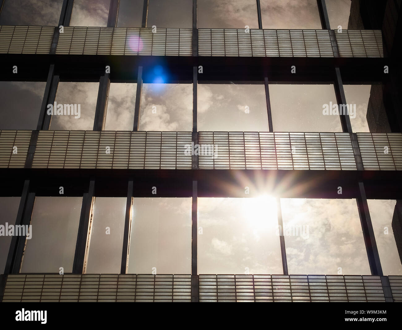 La luce del sole riflette brown/bronzo degli anni settanta-costruito ufficio complesso windows in file diritte con una prospettiva in diminuzione. Fontana Precinct, Sheffield Foto Stock