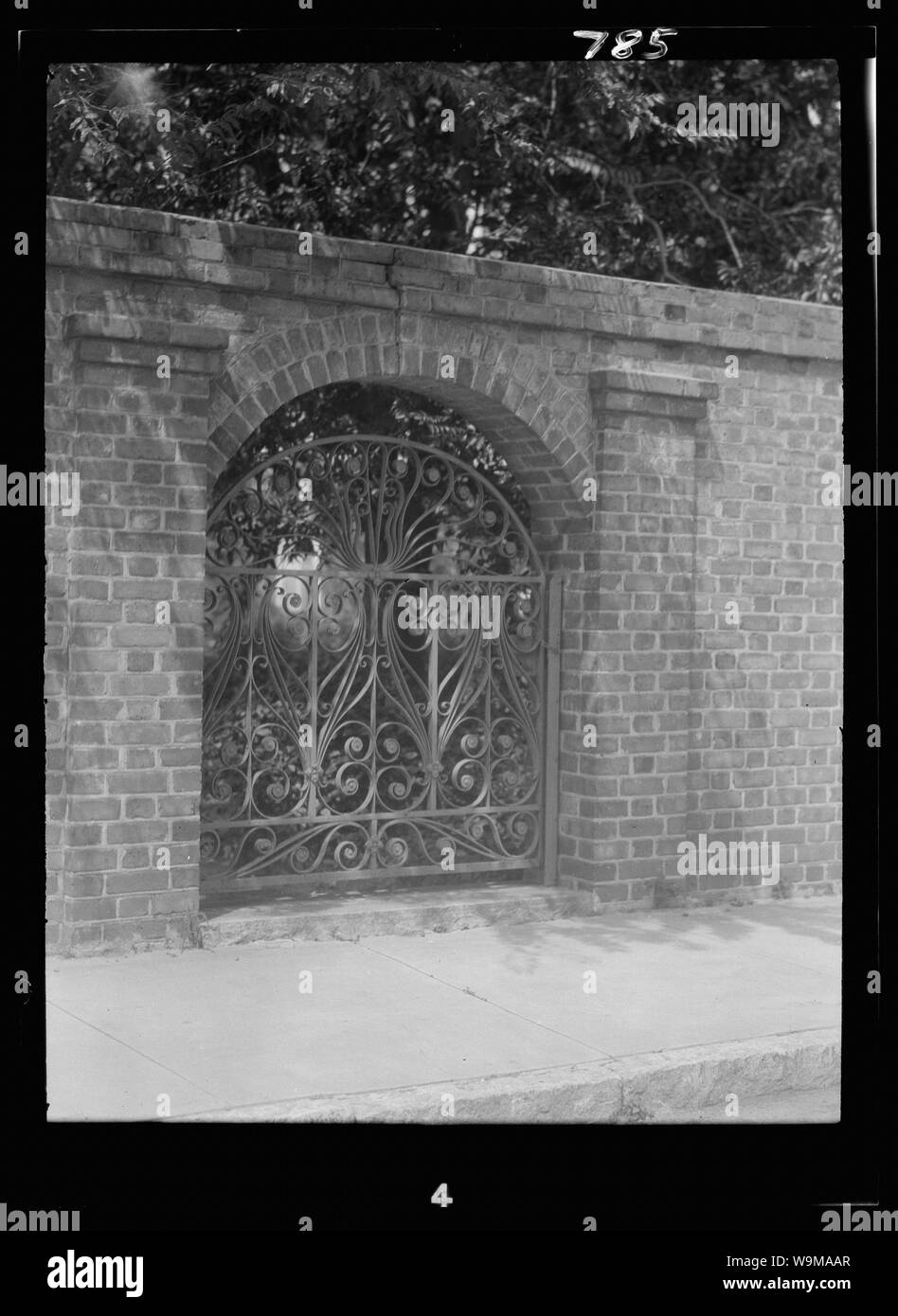Arcuata di ferro battuto cancello in free-standing muro di mattoni, New Orleans o Charleston, Carolina del Sud Foto Stock