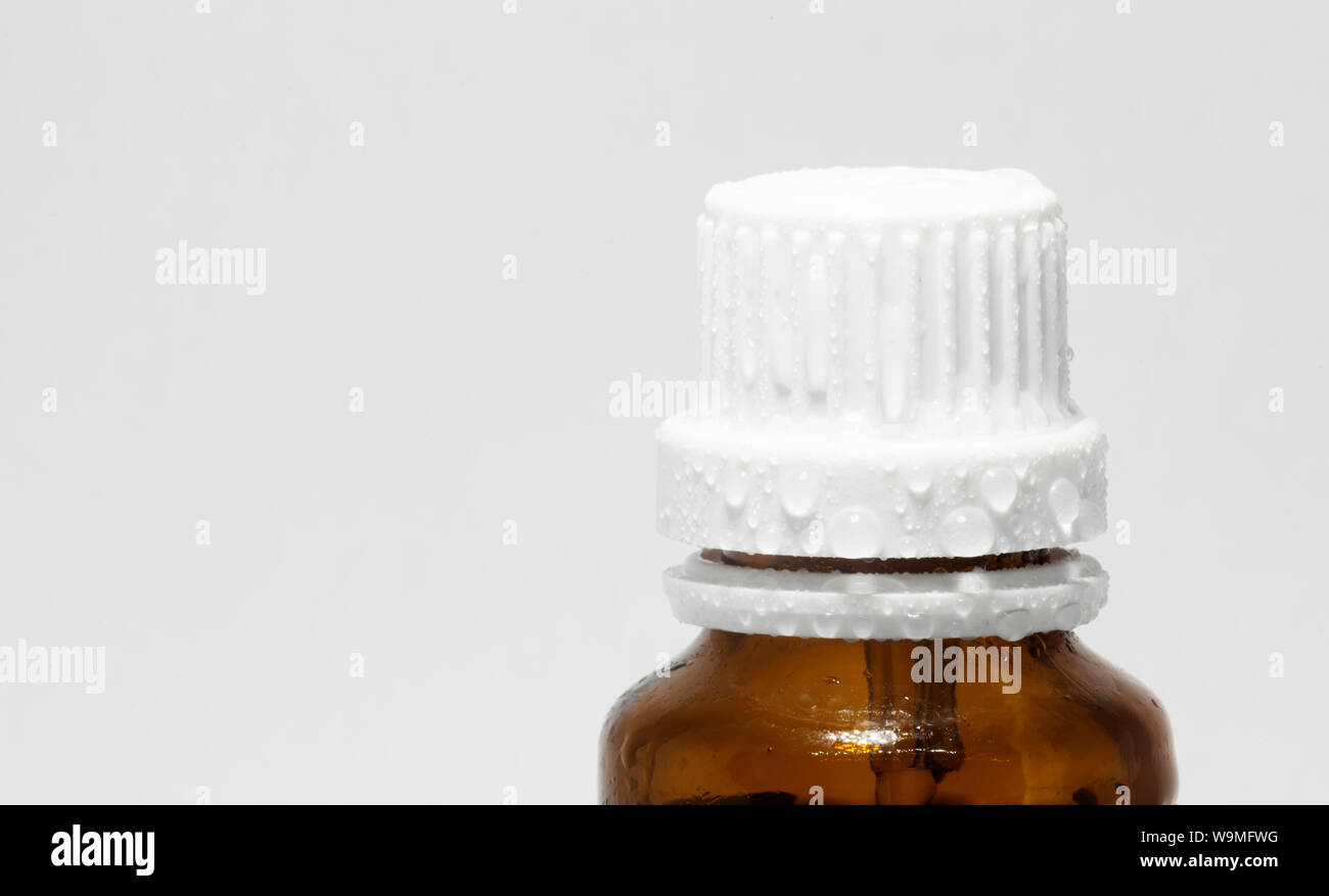 Tappo in plastica per un medecin bottiglia in studio luce con gocce d'acqua Foto Stock