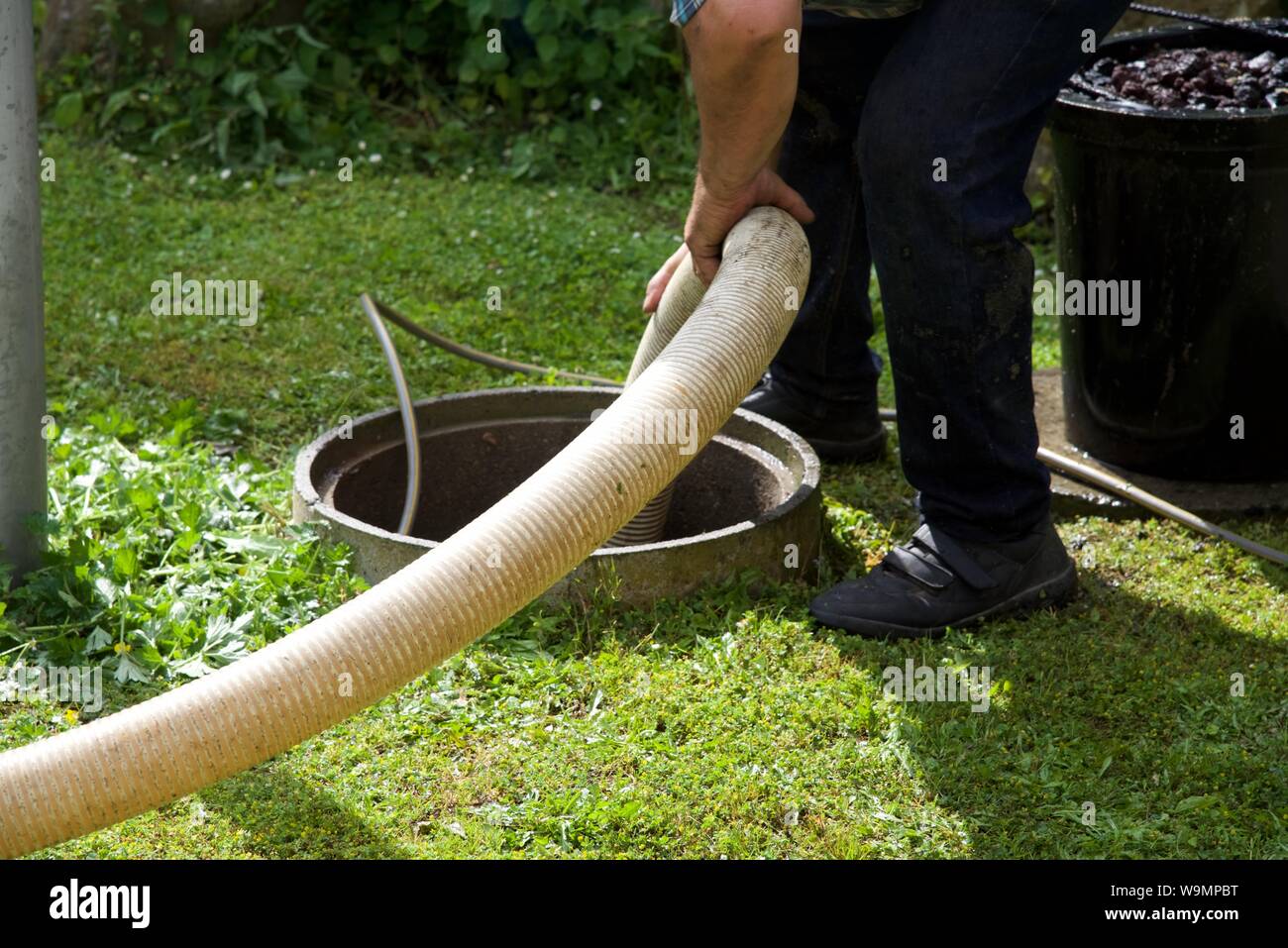 Fossa settica: la rimozione dei fanghi di depurazione e pulizia di un nazionale di serbatoio settico nel giardino rurale della proprietà francese. Foto Stock