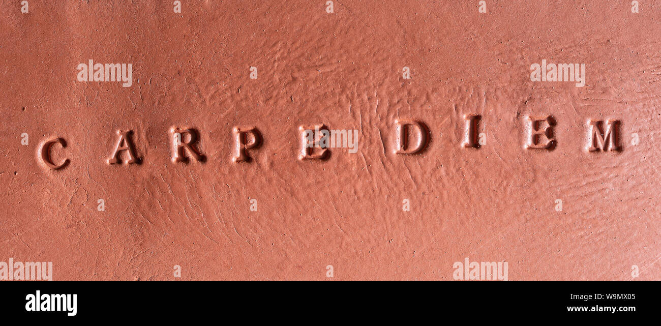La frase "Carpe Diem" scritta in latino su una tavoletta di terracotta Foto Stock