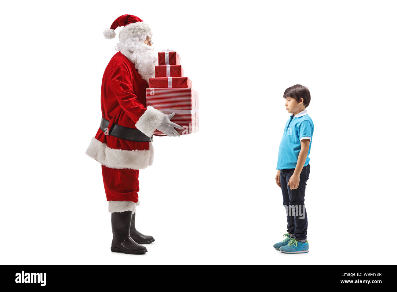 Completa il profilo di lunghezza shot di Santa Claus dando presenta a un triste ragazzo isolato su sfondo bianco Foto Stock