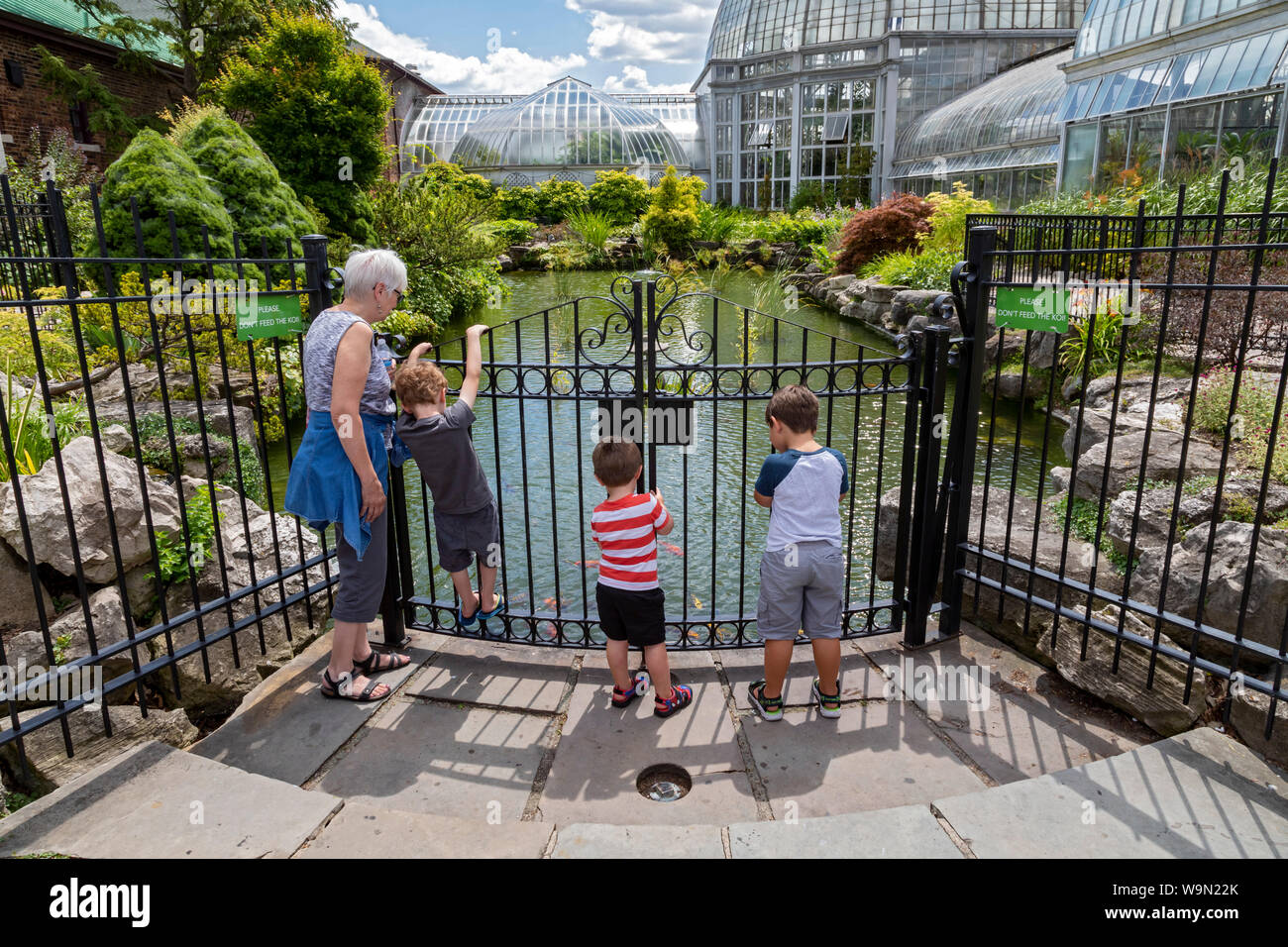 Detroit, Michigan - Bambini watch pesci di koi pond al Belle Isle Aquarium. Progettato da Detroit architetto Albert Kahn e aperto nel 1904, è t Foto Stock