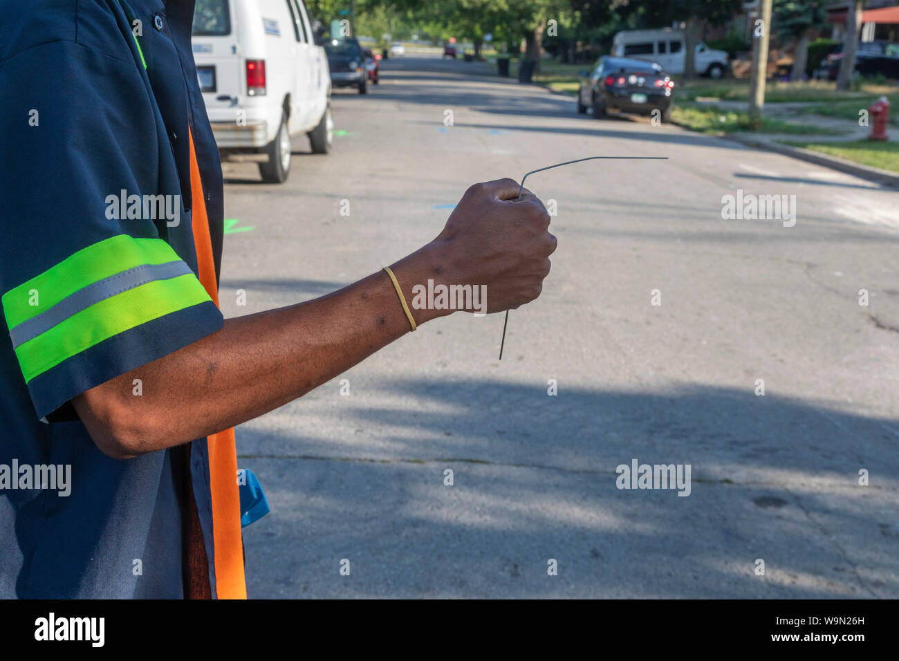 Detroit, Michigan - Un dipendente di Detroit acqua & dipartimento fognaria utilizza un'asta per aiutarlo a segnare la posizione delle reti idriche e fognarie linee su una resi Foto Stock