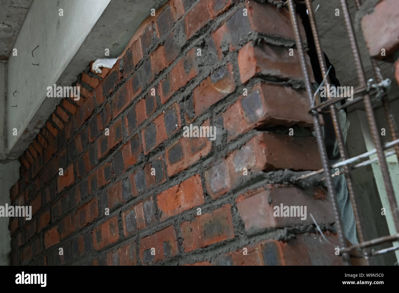 Stuccatore che compongono un muro di mattoni con cemento Foto Stock
