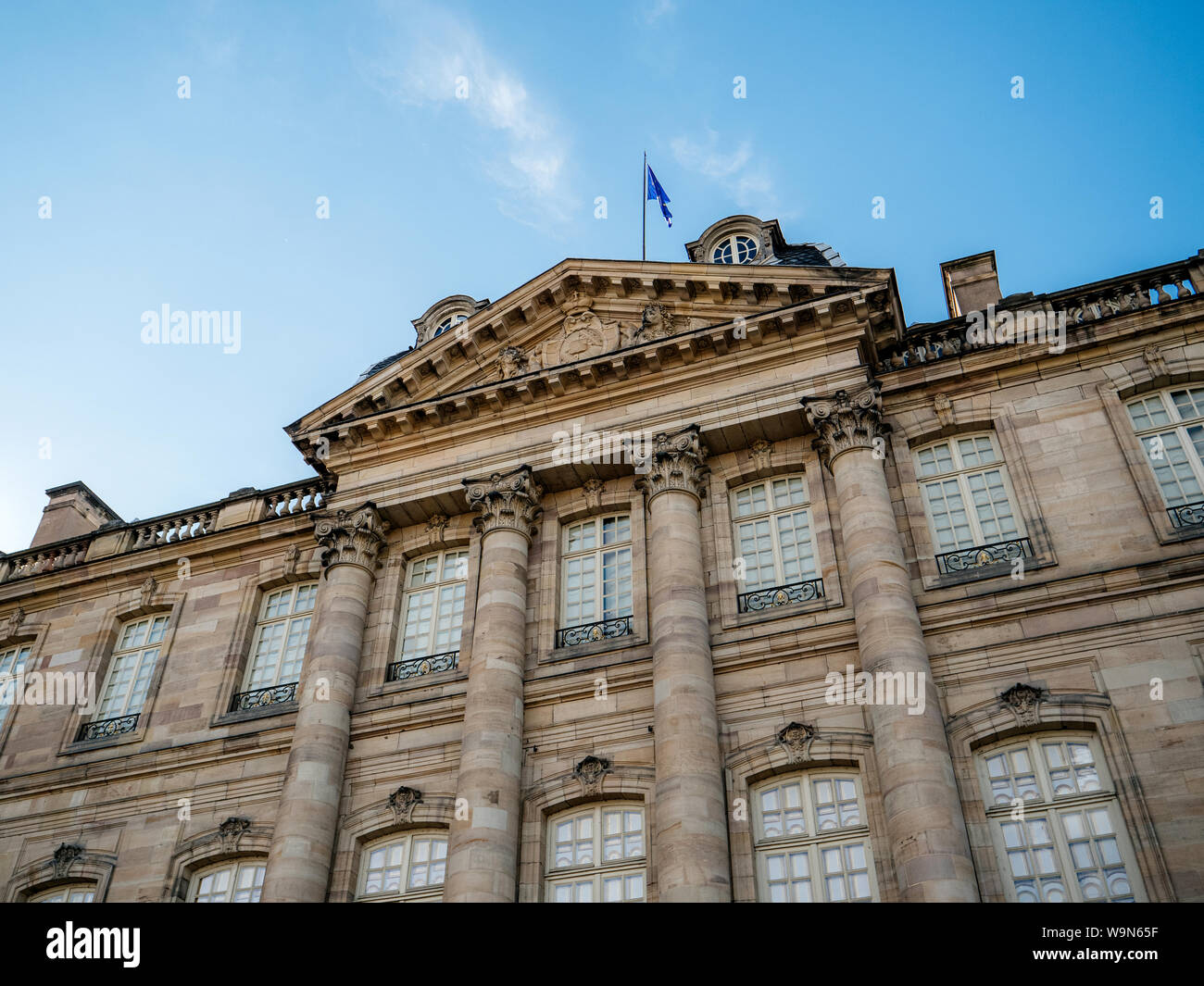 Basso angolo vista dell Unione Europea la Bandiera blu sventola serenamente sul tetto del Palais Rohan a Strasburgo con cielo blu chiaro in background Foto Stock