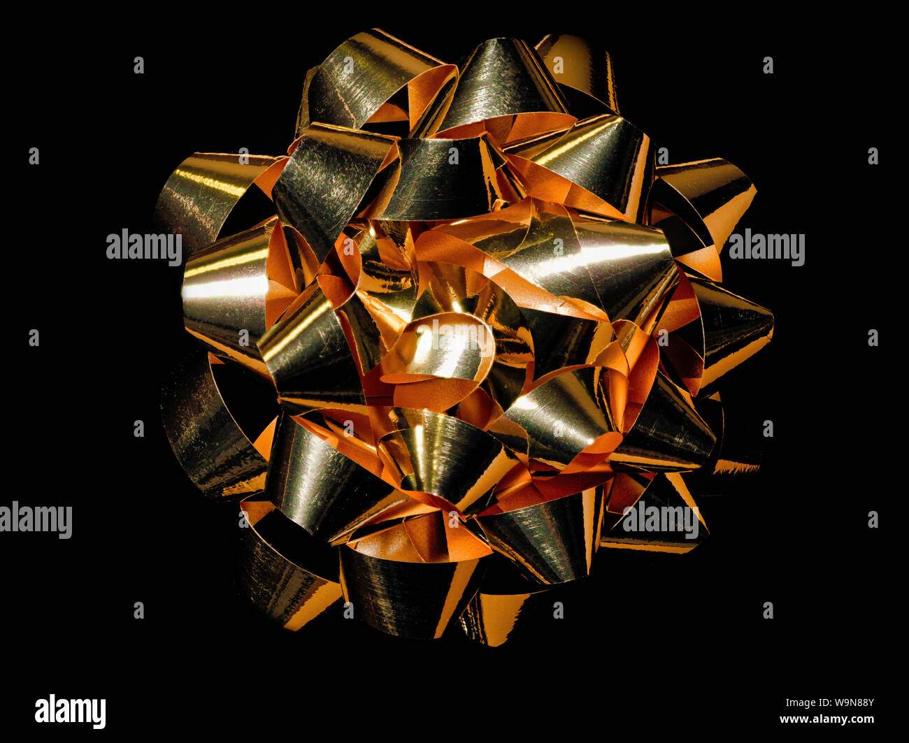 Oro luccicante Bow su sfondo nero Foto Stock
