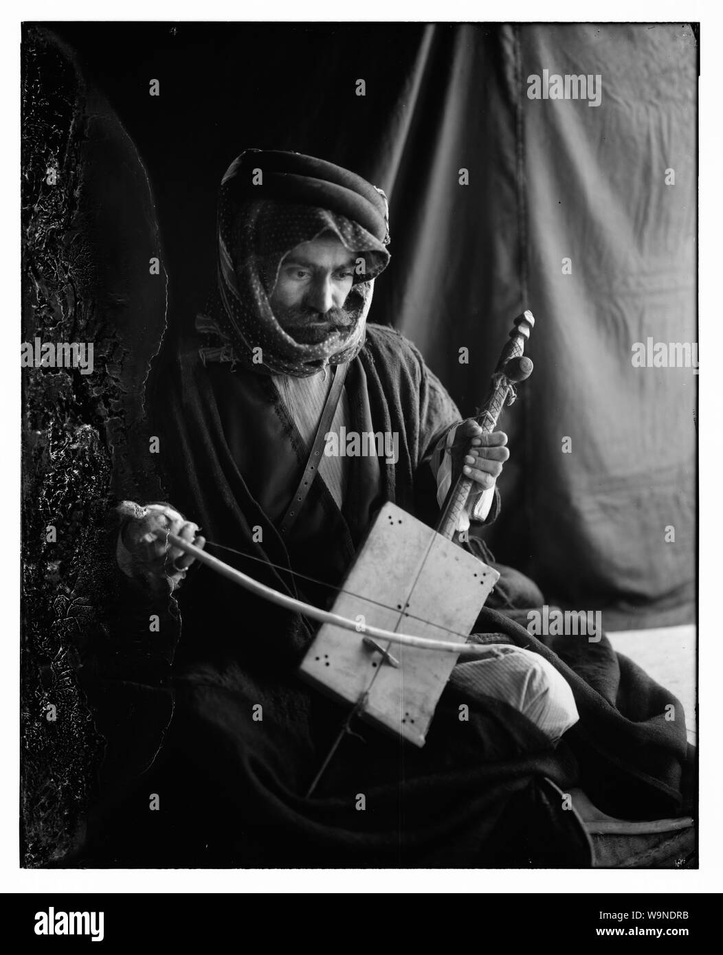 Uomo beduino giocando il rababeh (un unico strumento a corda) con un inchino Foto Stock
