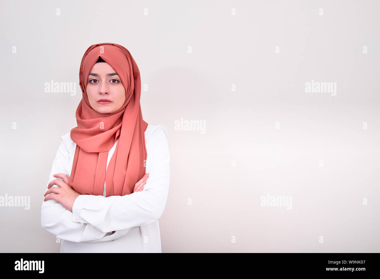 Ragazzina musulmana bracci ripiegati isolato con sfondo bianco, hijab insegnante musulmano o medico donna bracci ripiegati Foto Stock