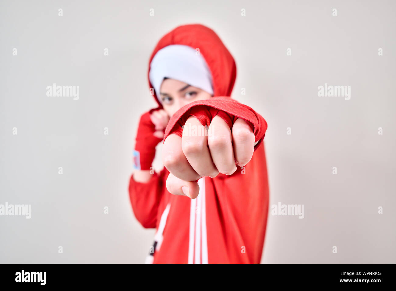 Donna boxer punch alla telecamera, boxer ragazza punzone con red guantoni da pugilato Foto Stock