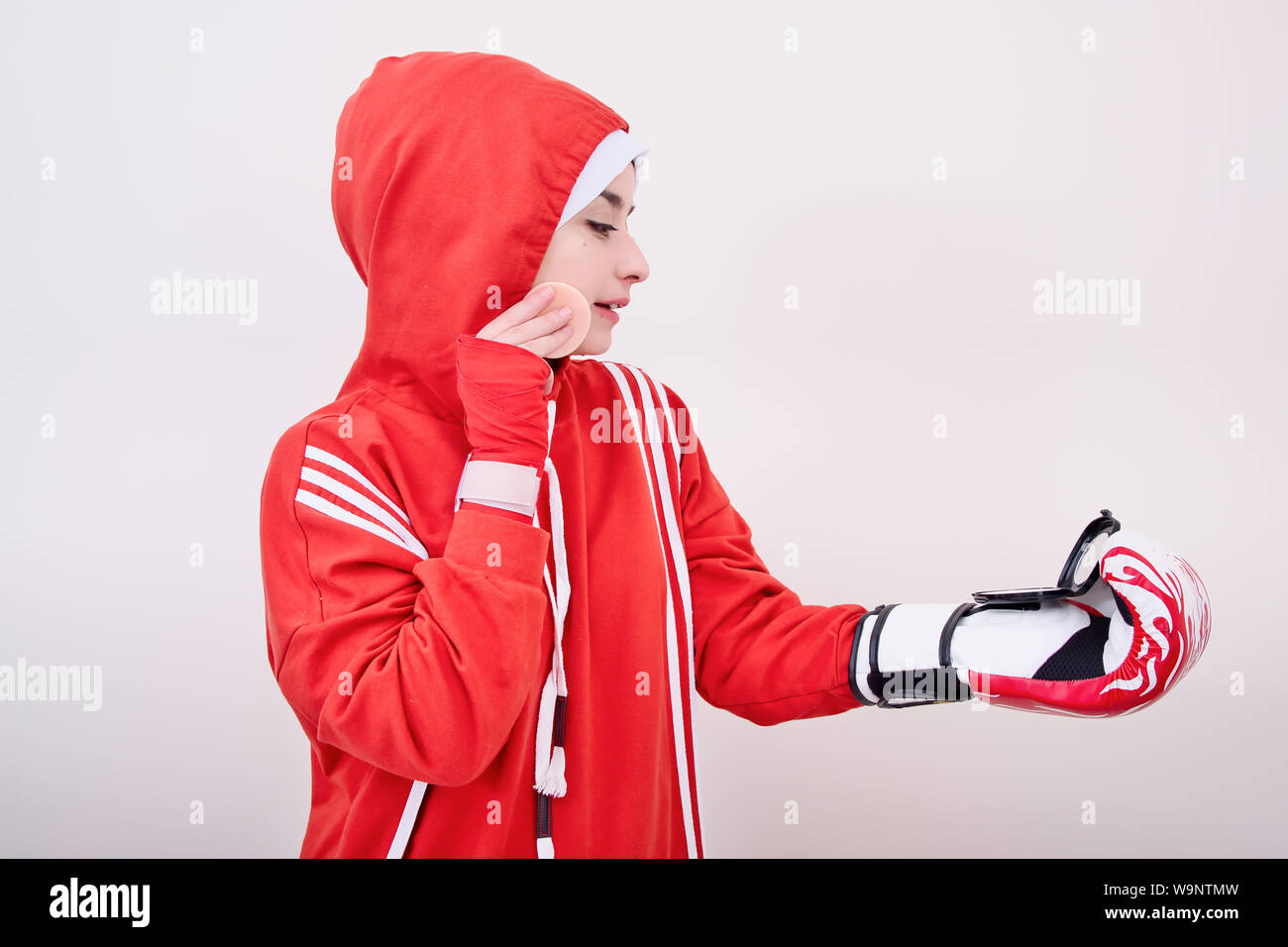 Ragazza boxer rosso di indossare abbigliamento sportivo e lei facendo trucco Foto Stock