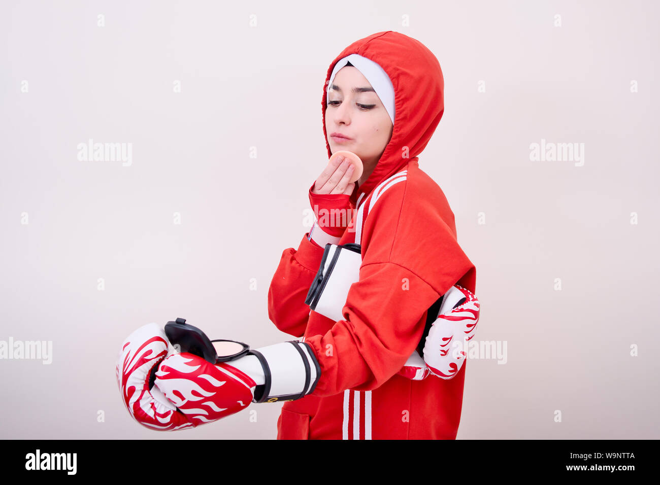 Ragazza boxer rosso di indossare abbigliamento sportivo e lei facendo trucco Foto Stock