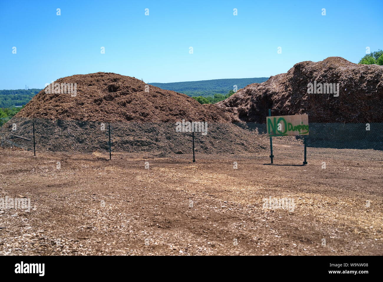 Un assenza di pratiche di dumping il segno inviato a un recintato in pile delle importazioni oggetto di dumping di strame. Foto Stock