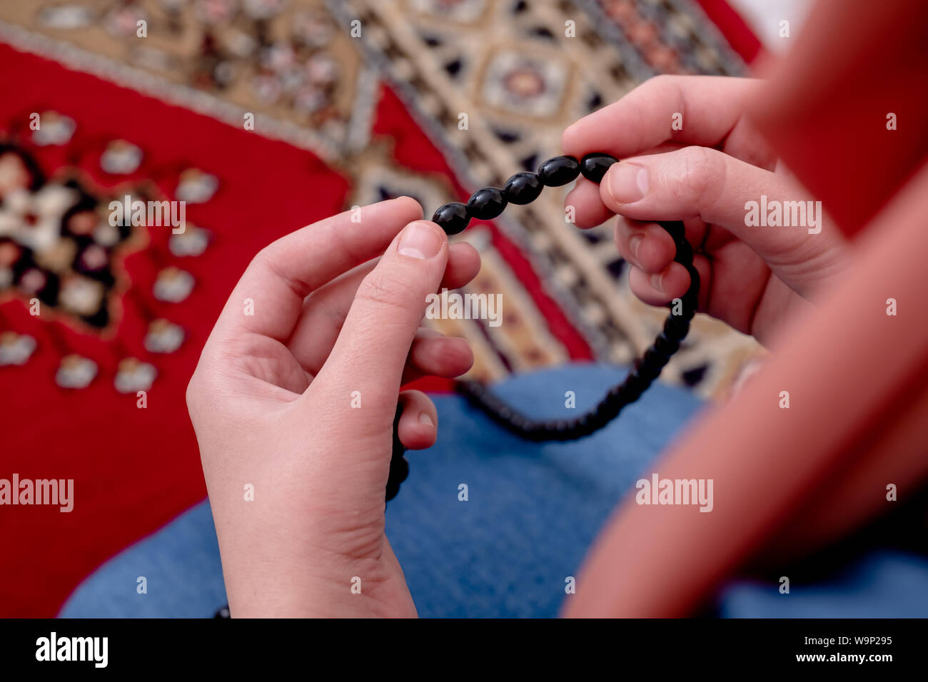 Donna musulmana la preghiera, la ragazzina musulmana aprire le mani pregando con Rug Foto Stock