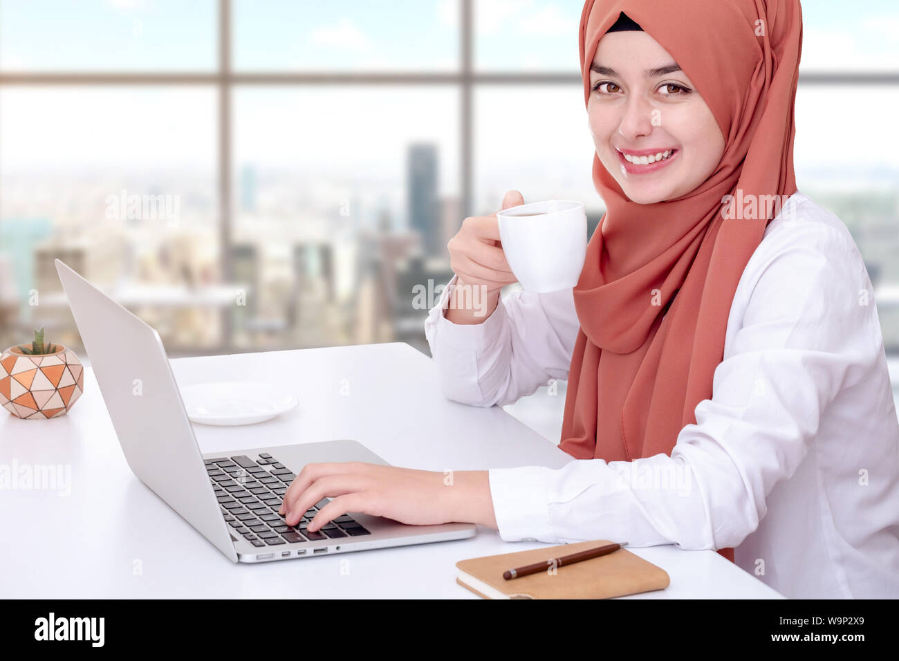 Il hijab donna musulmana lavoro con computer, musulmana ragazza seduta in ufficio Foto Stock