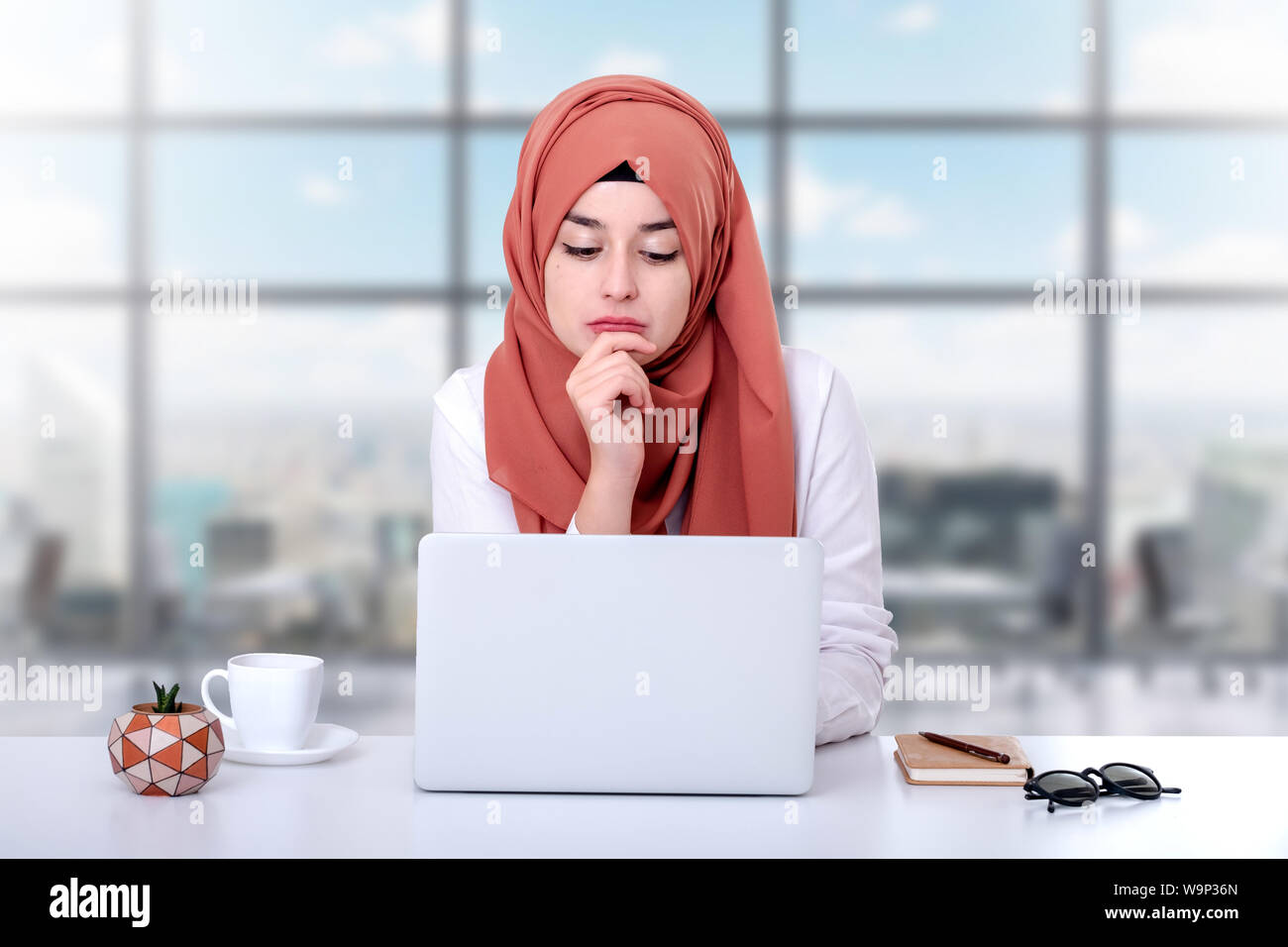 Il hijab donna musulmana lavoro con computer, musulmana ragazza seduta in ufficio Foto Stock